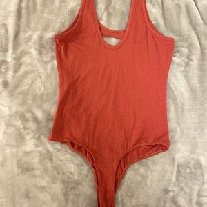 Burnt Orange bodysuit with cuts in it.